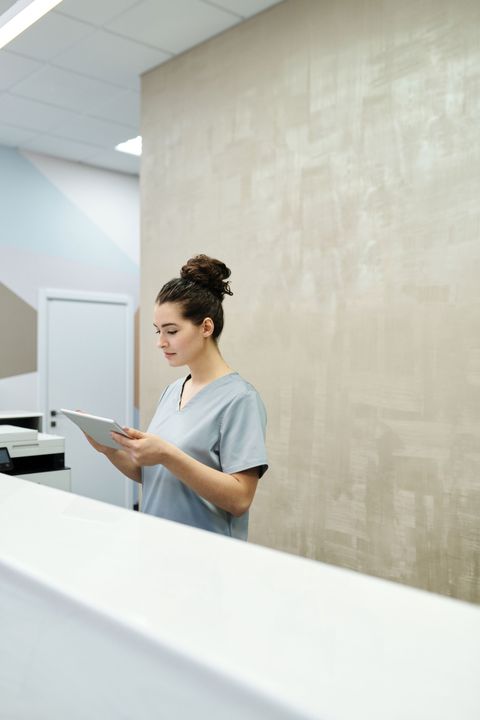A clinic receptionist reviewing an appointment book