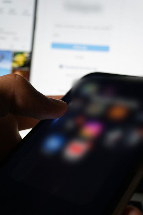 A person managing a business social media page on a laptop and phone